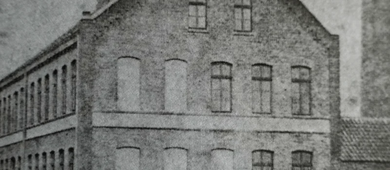 Historische Schwarz-Weiß-Aufnahme eines Gebäudes. Das Bild begleitet den Meilenstein zum Beginn der zentralen Stromversorgung und zur Gründung erster Elektrizitätsgenossenschaften im Jahr 1918.