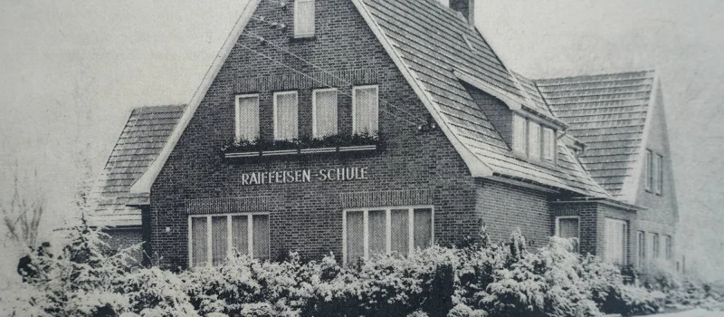 Historische Schwarz-Weiß-Aufnahme der Raiffeisenschule in Rastede. Das Bild begleitet den Meilenstein zur Eröffnung der Schule im Jahr 1952.