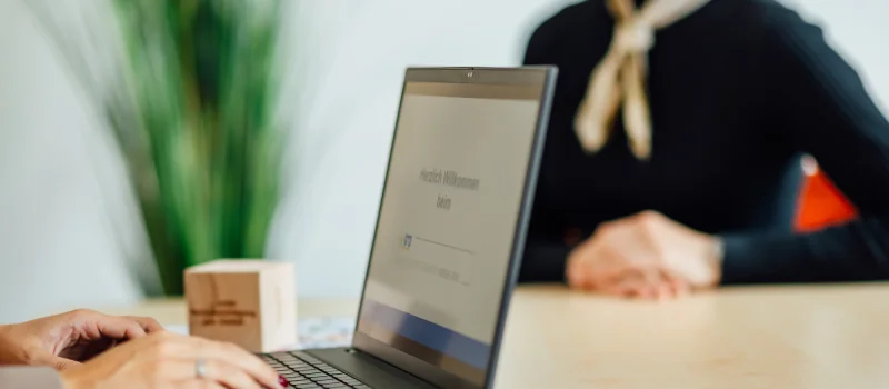 Eine Person arbeitet an einem Laptop, auf dessen Bildschirm die Begrüßung des Genossenschaftsverbands Weser-Ems zu sehen ist.