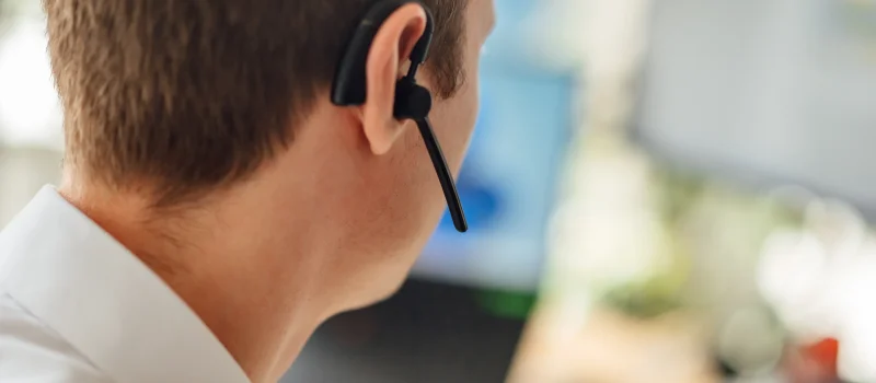Eine Person trägt ein Headset an einem Büroarbeitsplatz. Das Bild steht für persönliche Ansprechpersonen und direkte Unterstützung beim Genossenschaftsverband Weser-Ems.