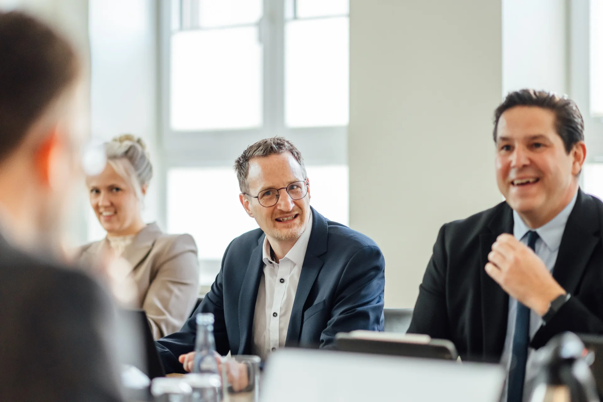 Mehrere Personen im Gespräch in einem Besprechungsraum. Das Bild steht für persönliche Beratung und Zusammenarbeit beim GVWE.
