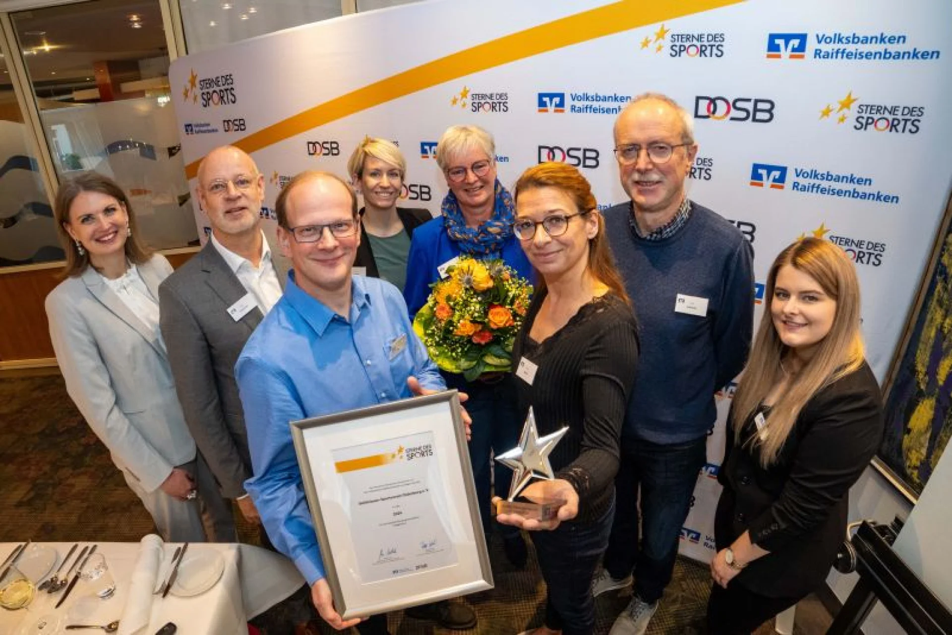 Der Gehörlosen Sportverein Oldenburg hat die Fahrkarte zum Bundesfinale nach Berlin gelöst. Das Bild zeigt (v.l.) Stephanie Hempel, Arbeitsgemeinschaft VR-Banken in Weser-Ems (AGVR), Matthias Osterhues, Vorstand Oldenburger Volksbank, Andre Danke, Vorstand Gehörlosensportverein Oldenburg (GSO), Christina Zschech, Oldenburger Volksbank, Heidrun Albrecht, Tania Danke, Heiner Albrecht, alle GSO, sowie Laura Lampe, AGVR.