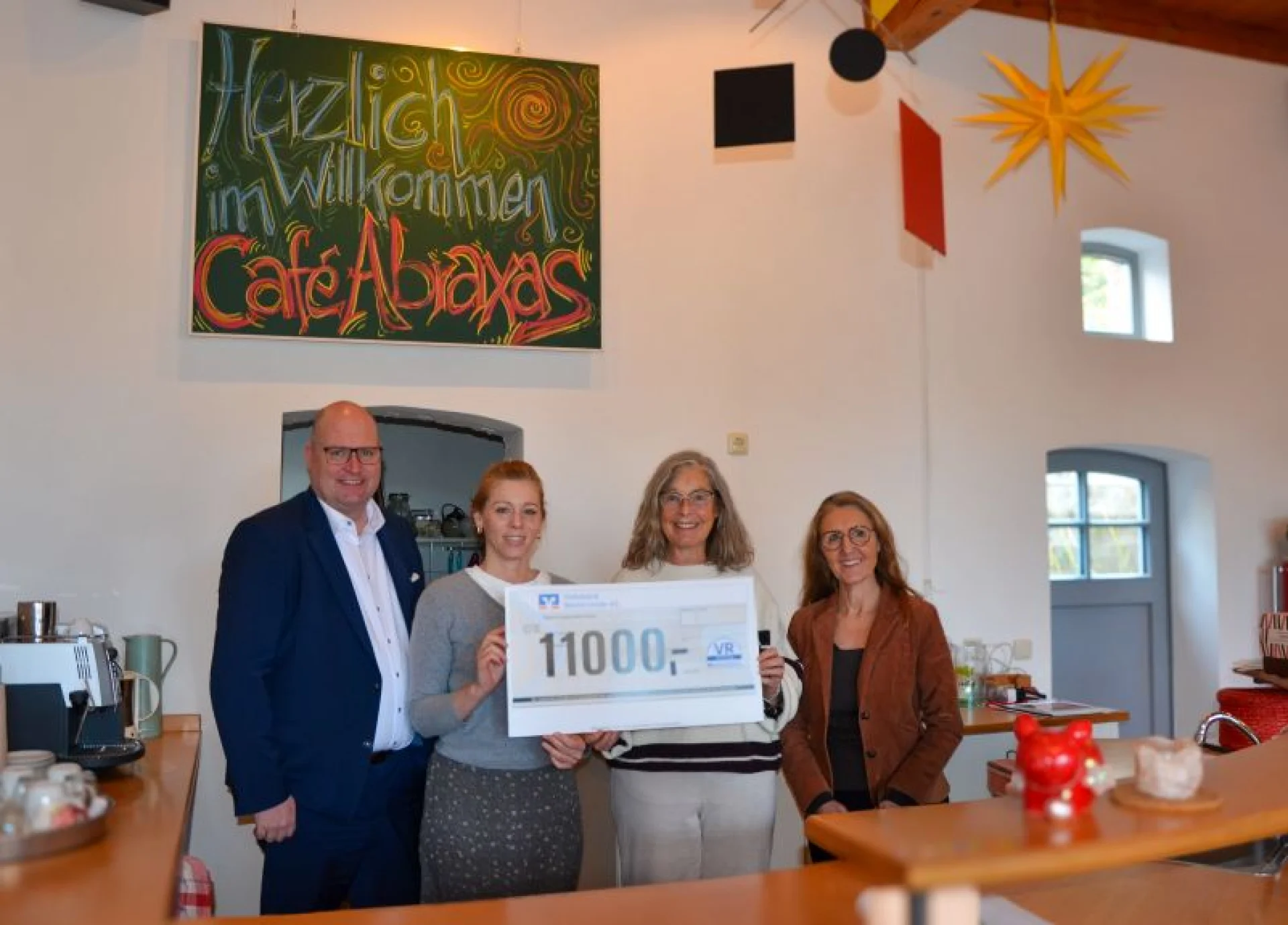Heute erstrahlt das Café in neuem Glanz. Lina Hofmann und Ortrud Kreft vom Abraxas Jugendkreativwerkstatt Kunstschule Westerstede e. V. (Mitte v. l.) freuen sich sehr über den durch Stefan Terveer, Vorstand Volksbank Westerstede eG und Anja Palloks, Marketing Volksbank Westerstede eG überreichten Scheck